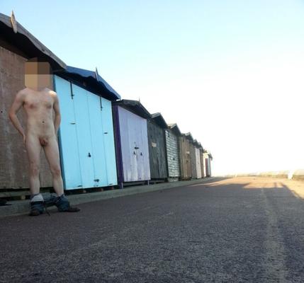 Naked under and around beach huts on a public UK beach