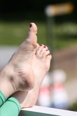 leggins verts pieds nus ongles rouges