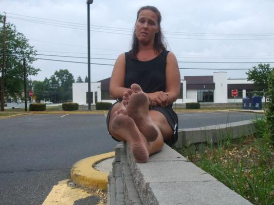 Donna Queen descalça em público posando na calçada