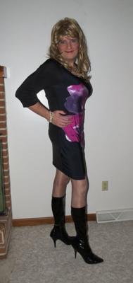 Crossdresser en robe violette et noire avec des bottes