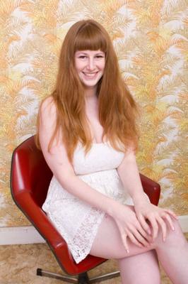 All natural redhead Chloe undresses in a chair