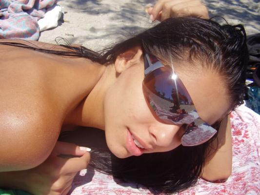 Adolescente latina en la playa en topless