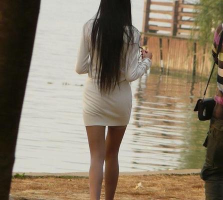 Chica en medias y su novio caminando por el lago.