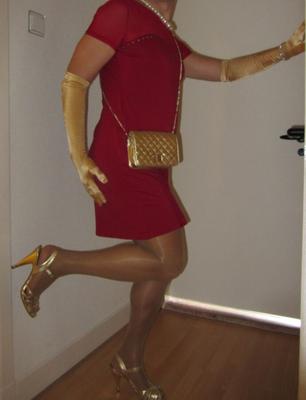 Cindy Cross crossdressing em um vestido vermelho e dourado